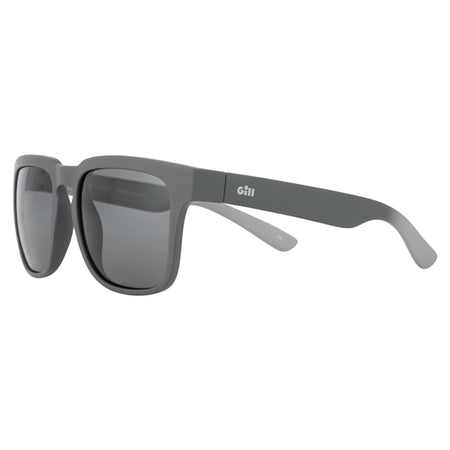 Gill 9744 Lumina solbrille på en båd, med strand i baggrunden